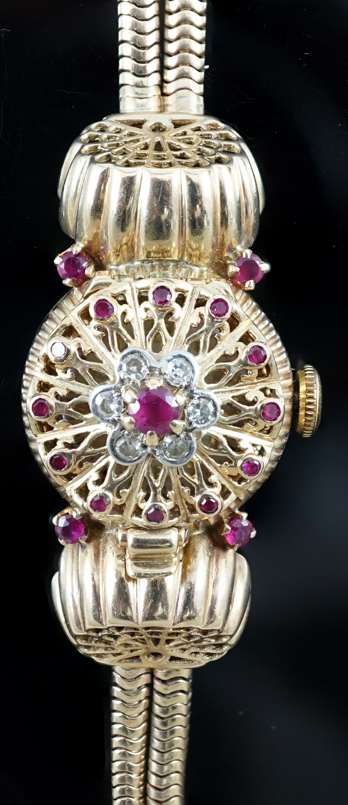 A lady's 1950's 9ct gold, ruby and diamond set manual wind cocktail watch, on a 9ct gold twin strand snake link bracelet